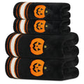 Four black Halloween towels with orange pumpkin motifs and striped borders