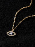 Close-up of the blue-and-white evil eye pendant with sparkling accents on black fabric