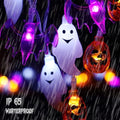Close-up of illuminated ghost, bat, and pumpkin light covers