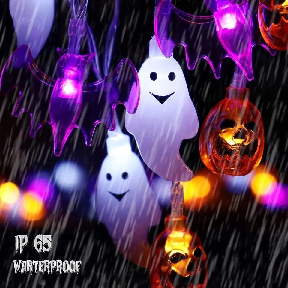 Close-up of illuminated ghost, bat, and pumpkin light covers