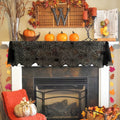Black lace runner draped across a mantel decorated with pumpkins