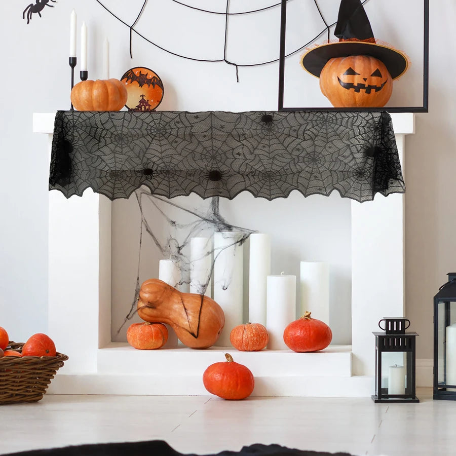 Black spiderweb lace mantel cover with orange pumpkin decorations