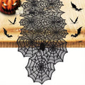 Black spiderweb table runner styled with Halloween decorations